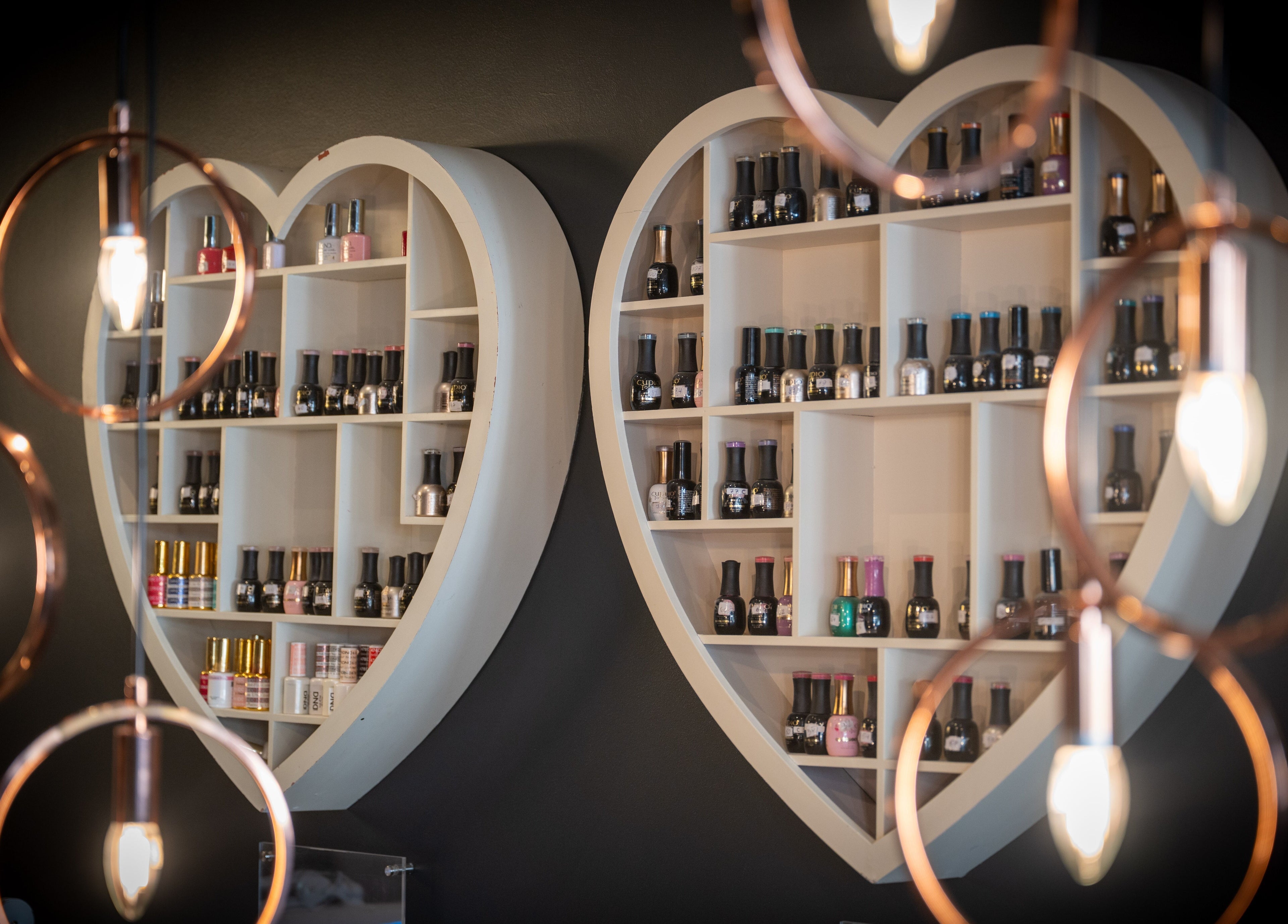 Elegant heart-shaped nail polish display at Perfect You, Teddington, England, GB showcasing vibrant bottles.