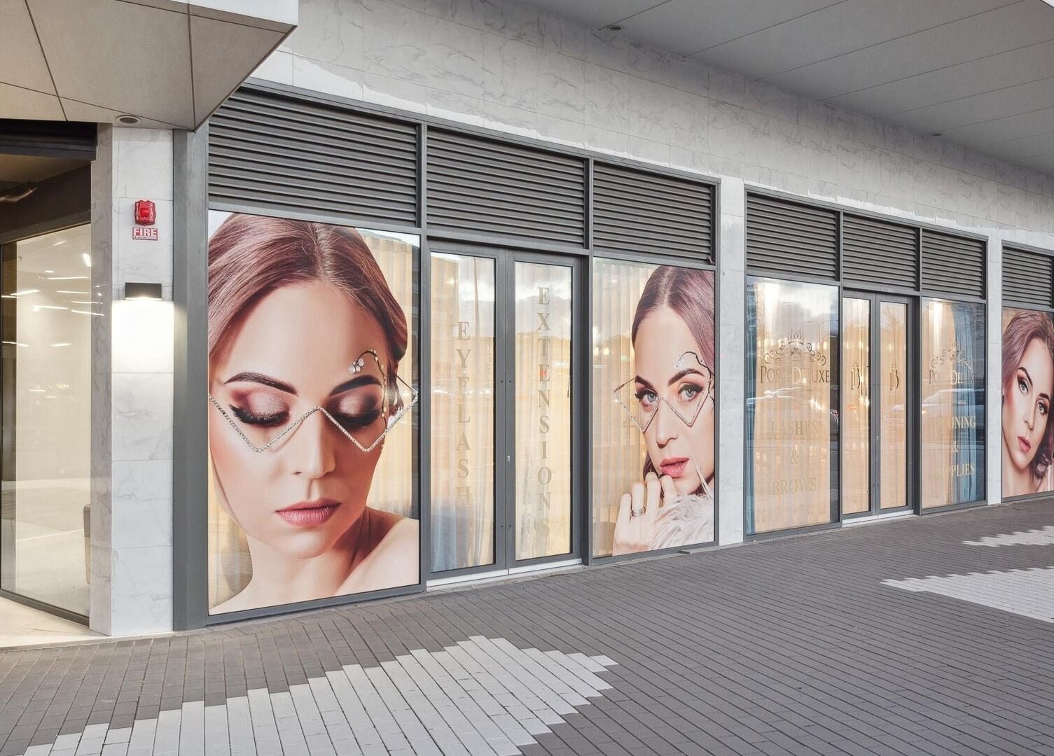 Front view of Posh Deluxe in Mount Pleasant showcasing stylish beauty posters on windows.