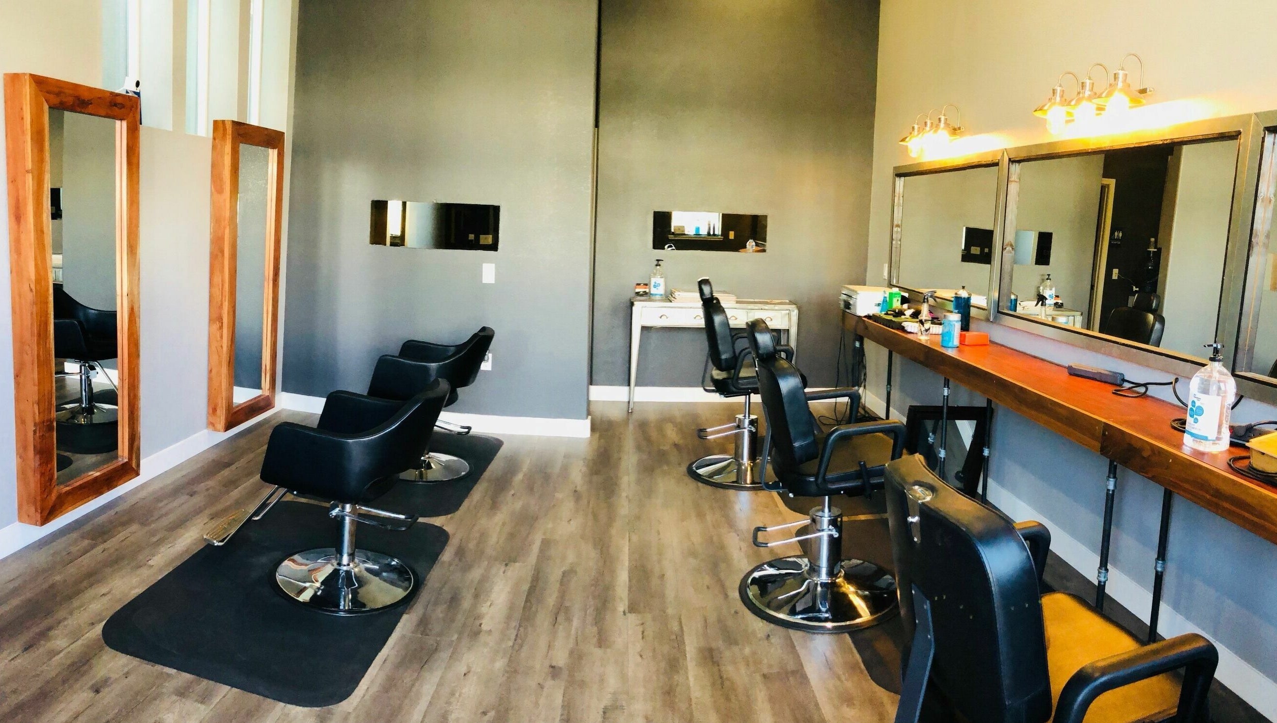 Modern salon interior at Dappers and Dolls in Milpitas, California, US with sleek styling chairs and large mirrors.