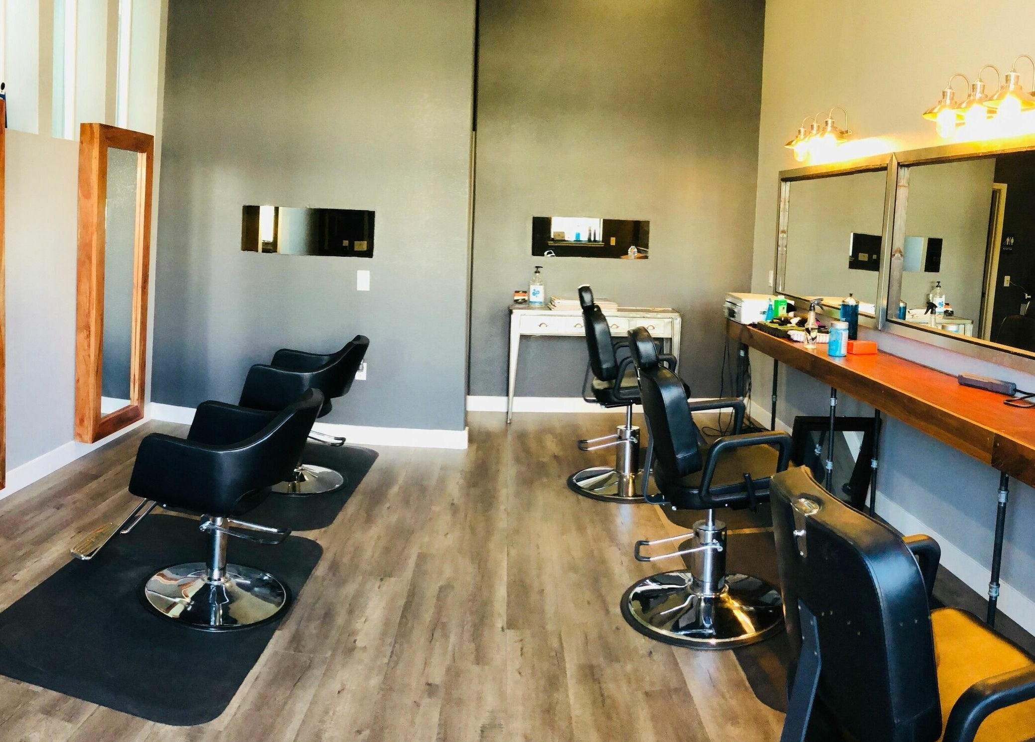 Modern salon interior at Dappers and Dolls in Milpitas, California, US with sleek styling chairs and large mirrors.