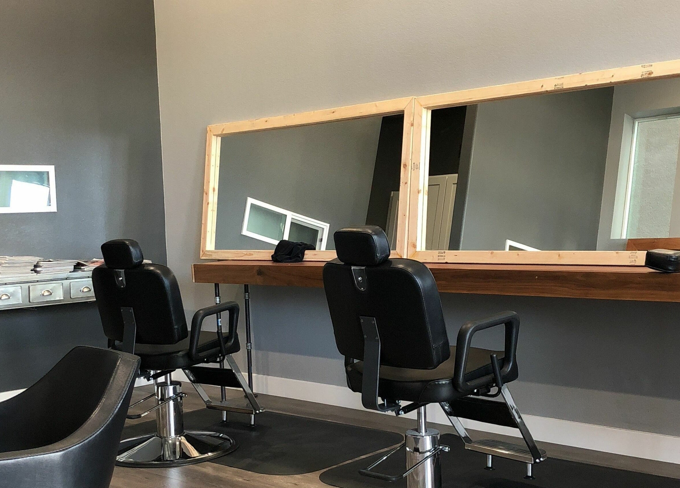 Modern salon chairs at Dappers and Dolls, Milpitas, California, US, styled with large mirrors for a chic experience.