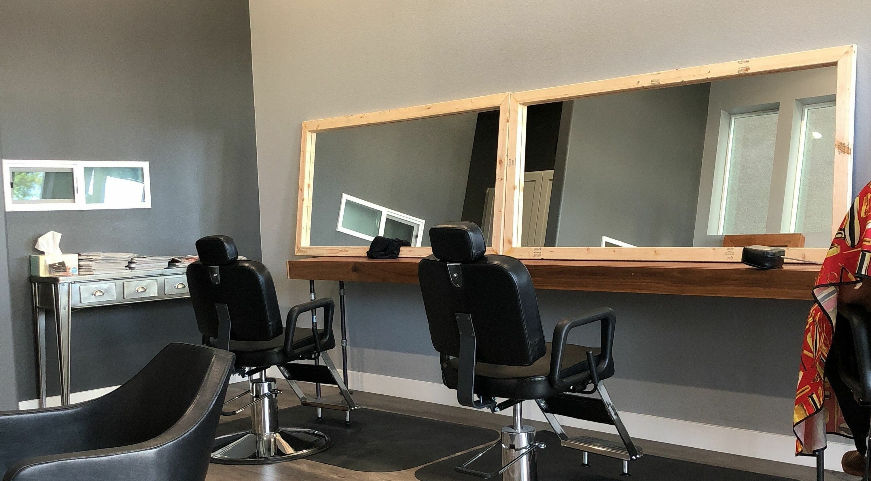 Modern salon chairs at Dappers and Dolls, Milpitas, California, US, styled with large mirrors for a chic experience.