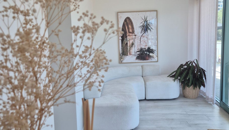 Elegant seating area at Iluka Skin, Maroochydore, Queensland, AU with plants and art enhancing the peaceful ambiance.
