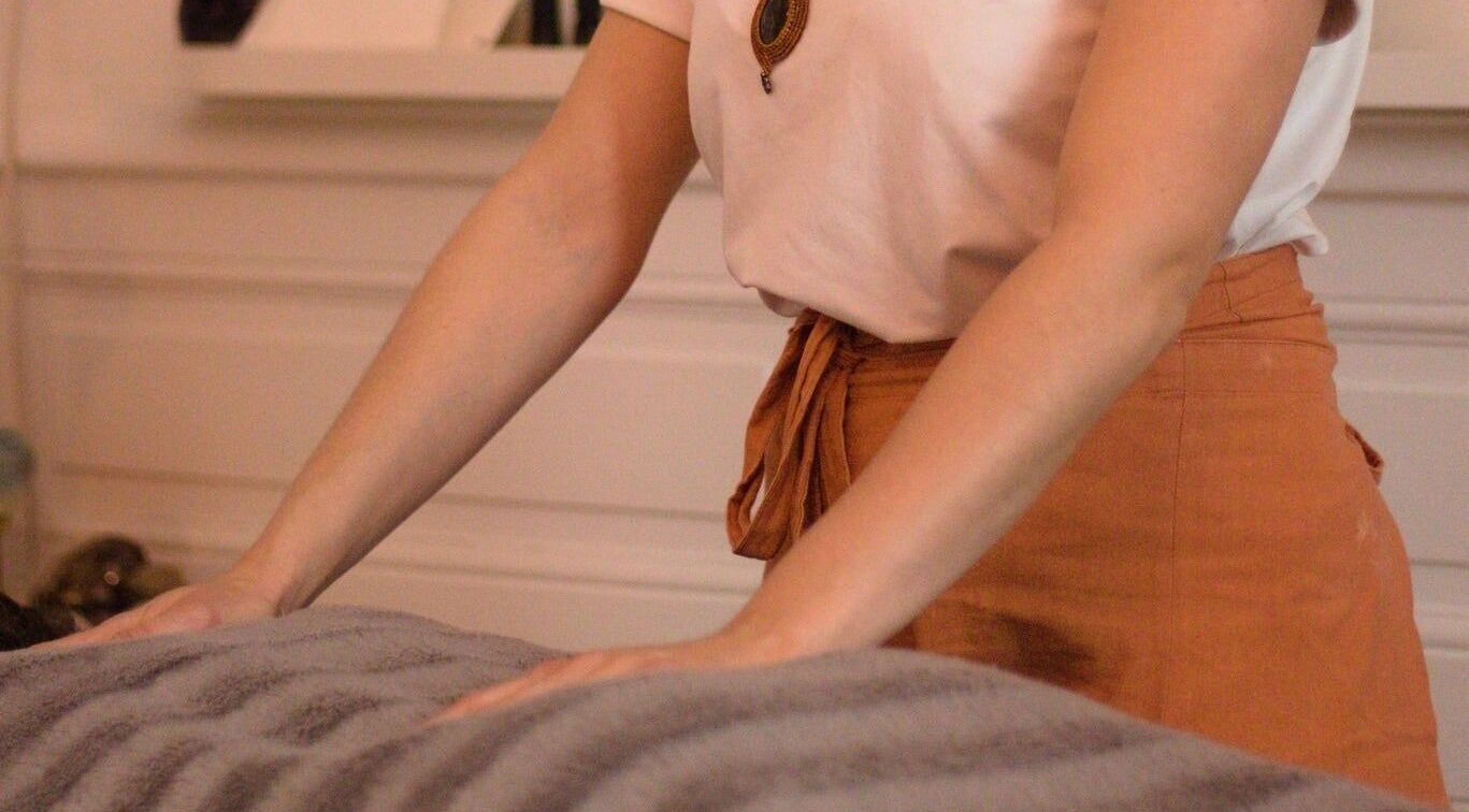 Thérapeute préparant une table de massage à Samaya Massages, Clermont-Ferrand, Auvergne-Rhône-Alpes, FR.