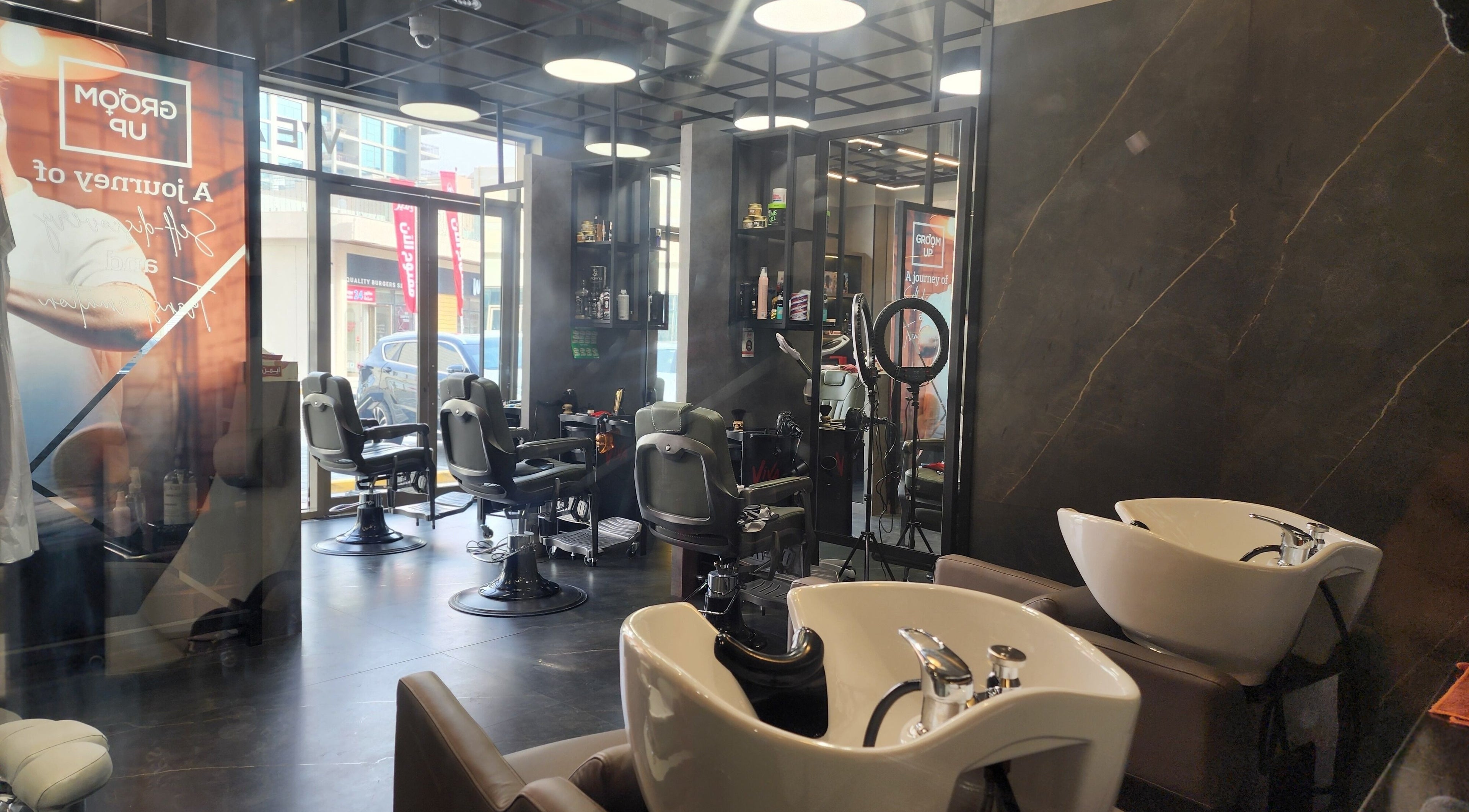 Modern interior of Groom Up Gents Salon in Dubai, Dubai, AE showcasing styling chairs and wash stations.