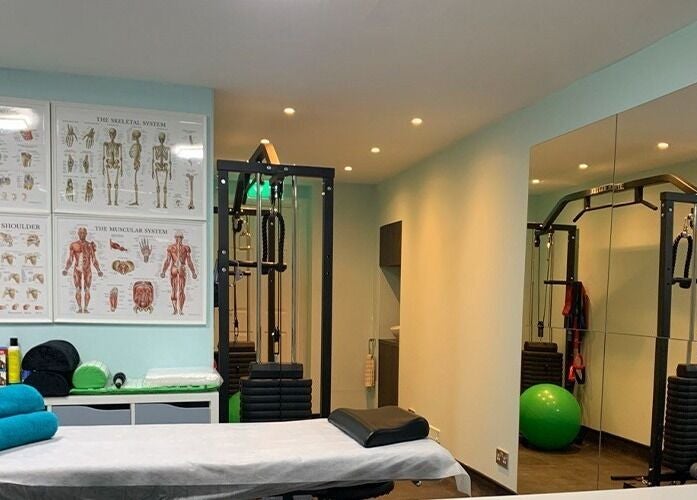 SPINEWELL therapy room with massage table and exercise equipment in Dunfermline, GB.