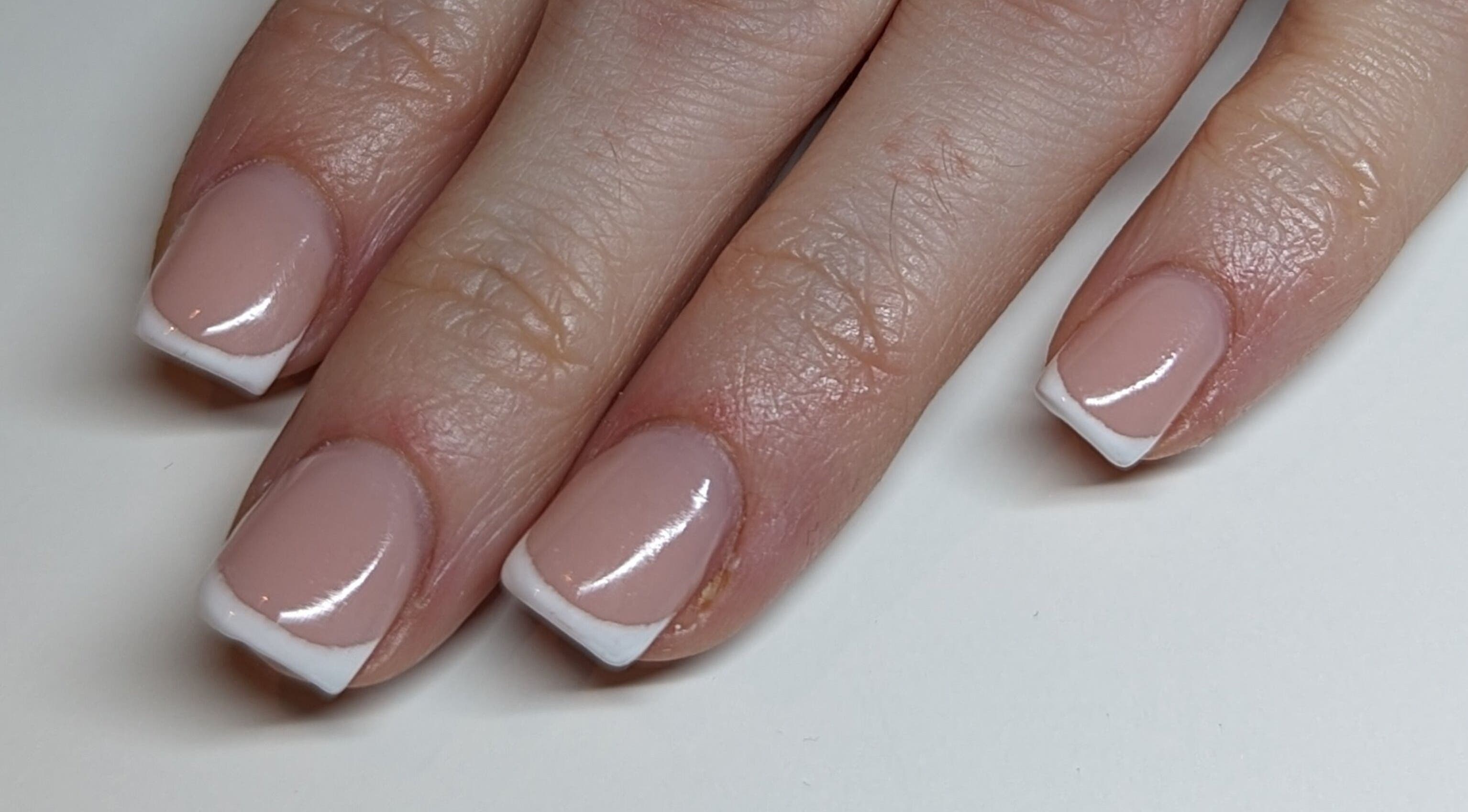 Classic French manicure at Kmac Studio, Dunbar, Scotland, GB. Pink nails with white tips, elegant and glossy.