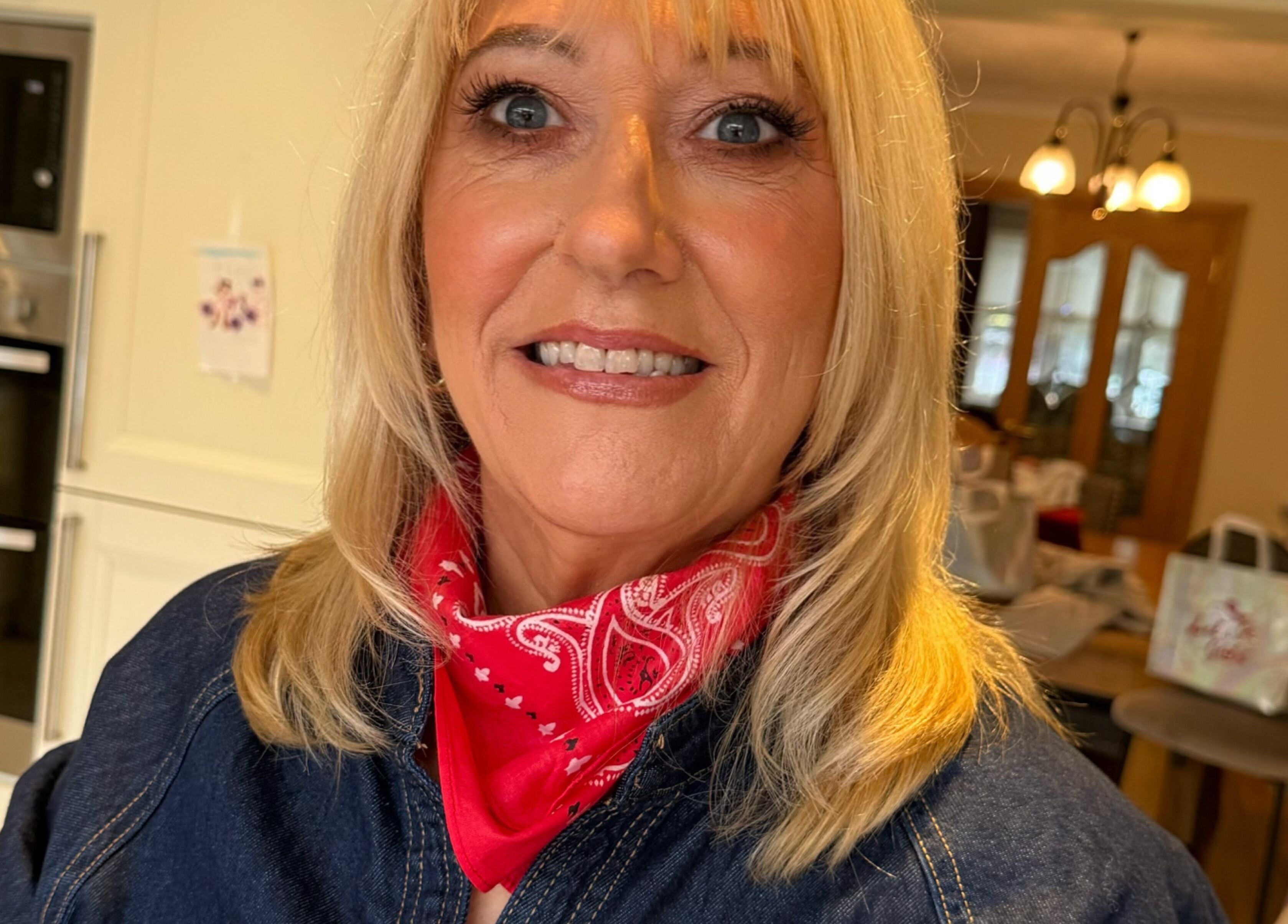 Smiling woman in red scarf at LuminousGlowStudio, Clane, County Kildare, IE, showcasing beauty care.