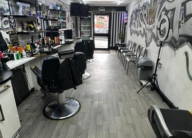 Interior of Boss Kutz Barbers featuring stylish chairs and urban graffiti in Birmingham, England, GB.