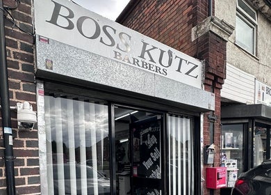 Exterior of Boss Kutz Barbers, Birmingham, England, GB with bold signage and modern storefront.