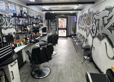 Interior of Boss Kutz Barbers in Birmingham, England, GB featuring graffiti art and stylish barber chairs.