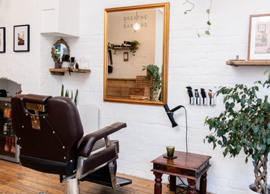 Elegant interior of Breathe Barbers in London, England, GB, showcasing a stylish chair and mirror setup.