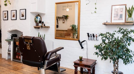 Elegant interior of Breathe Barbers in London, England, GB, showcasing a stylish chair and mirror setup.