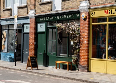 Street view of Breathe Barbers in London, England, GB with charming greenery and classic signage.