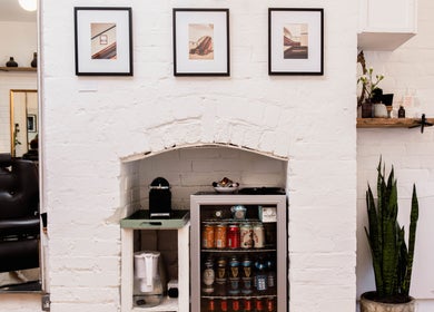Elegant interior of Breathe Barbers with stylish decor in London, England, GB, featuring framed art and a cozy setup.