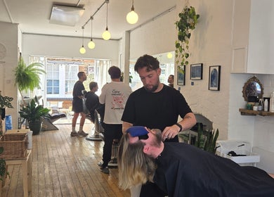 Breathe Barbers in London, England, GB, showcasing a stylish interior with a barber attending a relaxed client.