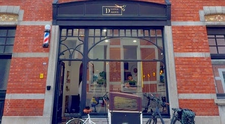 Voorgevel van Dakhil Kapper in Turnhout, Vlaams Gewest, BE, met klassieke bakstenen en grote ramen.