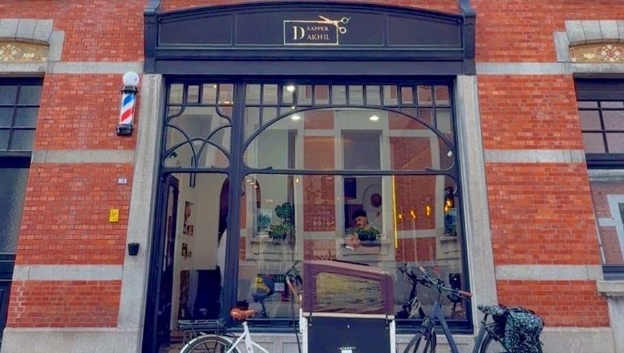 Exterieur van Dakhil Kapper, Turnhout, Vlaams Gewest, BE, met traditionele bakstenen gevel en fietsen buiten.