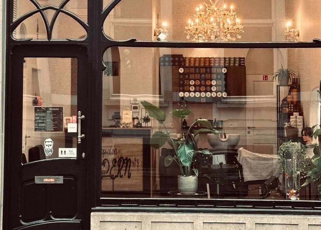 Vooraanzicht van Dakhil Kapper, elegant verlicht met kroonluchter in Turnhout, Vlaams Gewest, BE.