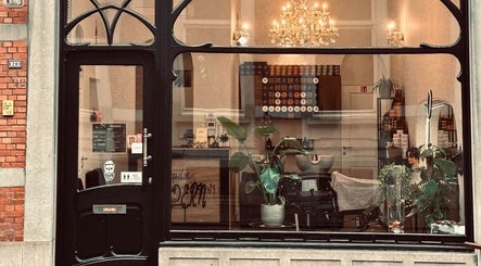 Vooraanzicht van Dakhil Kapper, elegant verlicht met kroonluchter in Turnhout, Vlaams Gewest, BE.