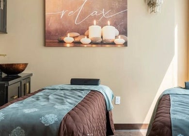 Tranquil massage room at Luxe Wellness Spa in Sugar Land, Texas, US with candles and massage beds.