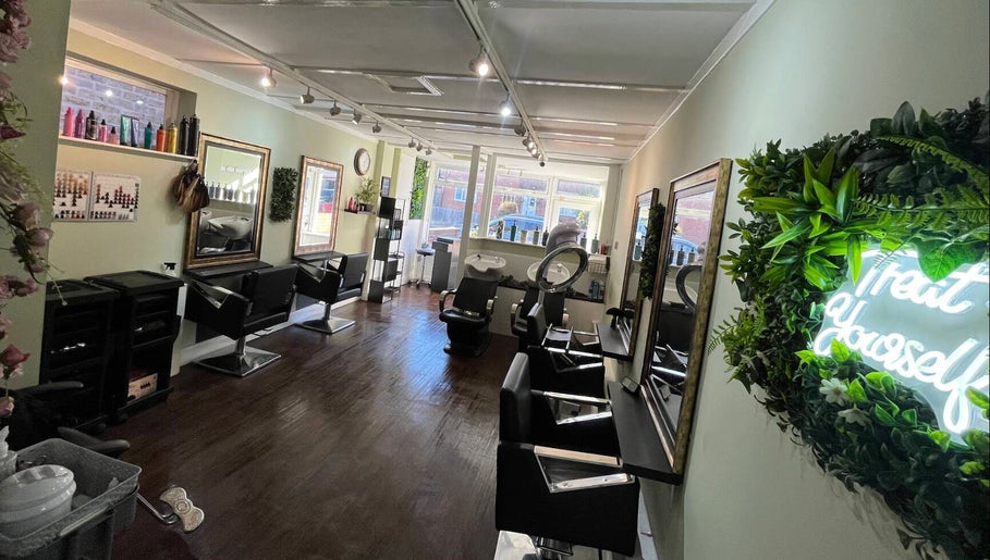Modern salon interior of Hair by Faye in Colchester, England, GB with stylish mirrors and neon sign.