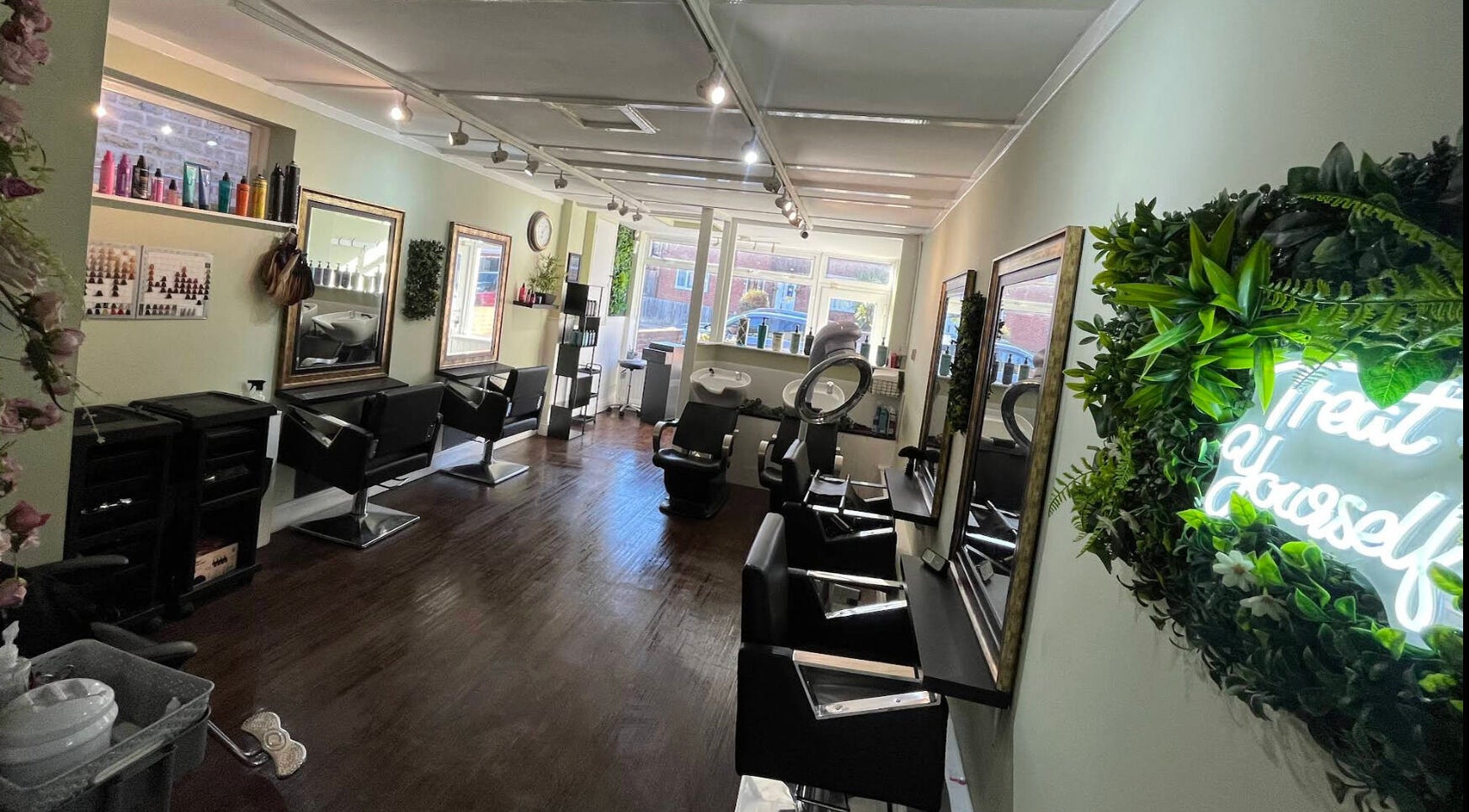 Modern salon interior of Hair by Faye in Colchester, England, GB with stylish mirrors and neon sign.