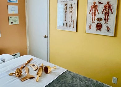 Massage tools on bed at Leonora - Massage Therapist, Pointe-Caire, Québec, CA. Cozy therapy room setting.