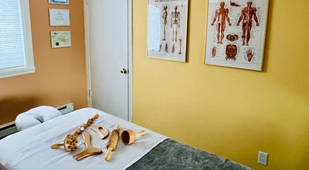 Massage tools on bed at Leonora - Massage Therapist, Pointe-Caire, Québec, CA. Cozy therapy room setting.