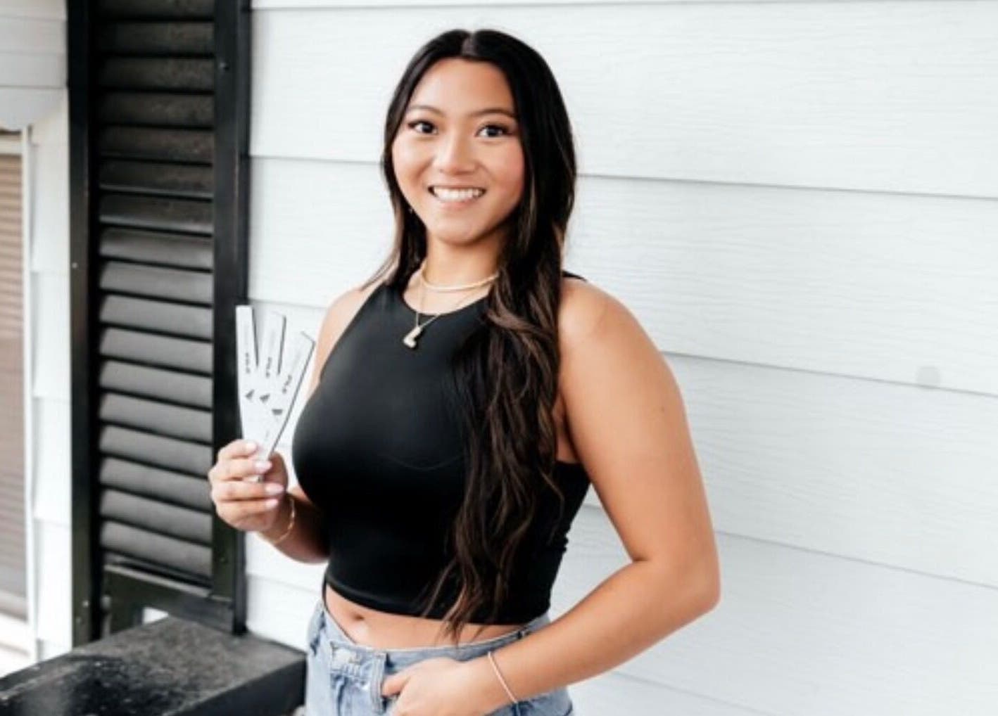 Smiling woman at Happy Nails Spa, Bolivar, Missouri, displaying stylish nail designs.