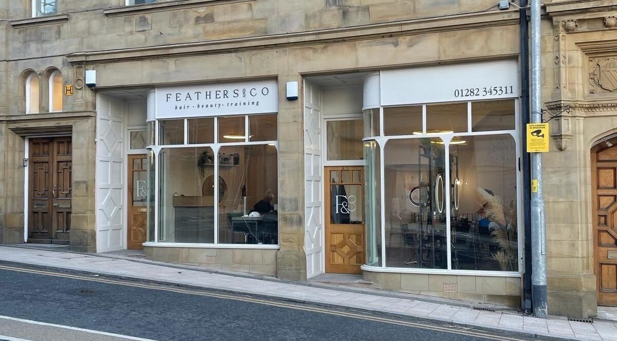 Front view of Feathers and Co at Padiham, England, GB, showcasing elegant glass windows and signage.