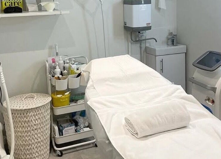 Professional treatment room at Feathers and Co, Padiham, England, GB with modern equipment and crisp white linens.