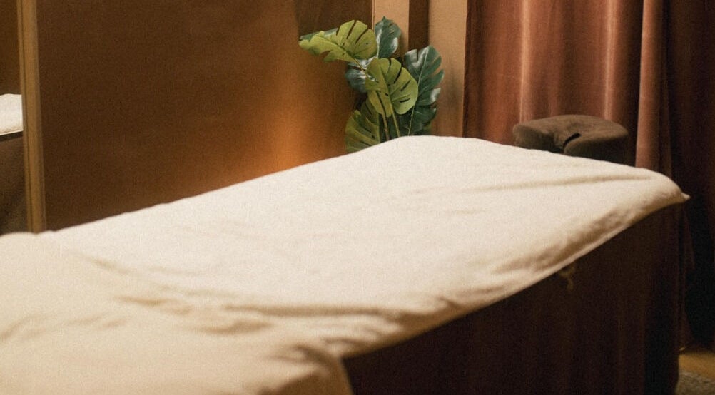 Cabine de massage sereine à Lymfea - Le Sanctuaire, Paris, Île-de-France, FR, avec plante apaisante.