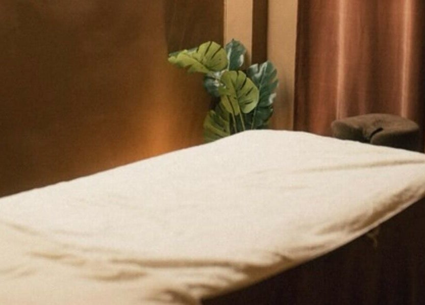 Table de massage à Studio by Holy, Paris, Île-de-france, FR, avec rideaux marrons et feuillage apaisant.