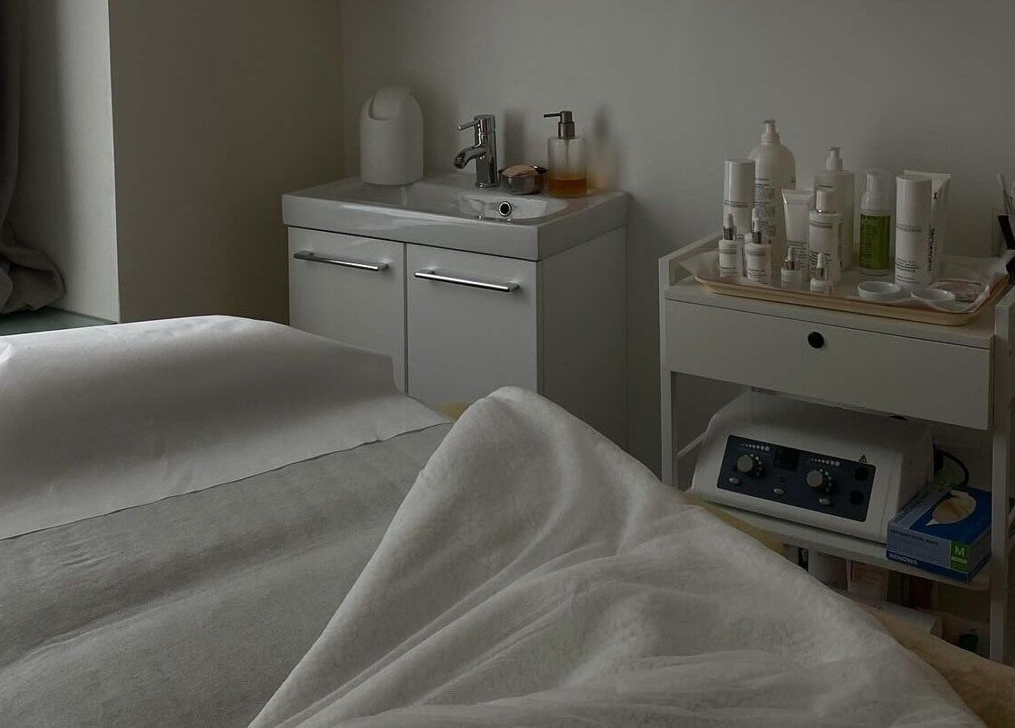 Salle de soins raffinée à Klaris Esthétique, Paris, Île-de-France, FR avec lit et produits de beauté.