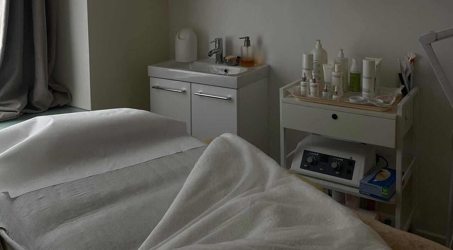 Salle de soins raffinée à Klaris Esthétique, Paris, Île-de-France, FR avec lit et produits de beauté.