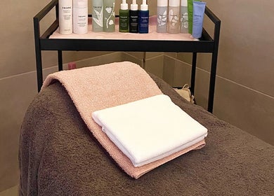 Glow it spa treatment room with towels and products in Limenas Chersonisou, GR, offering serene relaxation.