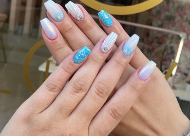 Stylish iridescent nails at Glow it, Limenas Chersonisou, GR, showing elegant blue and white ombre designs.