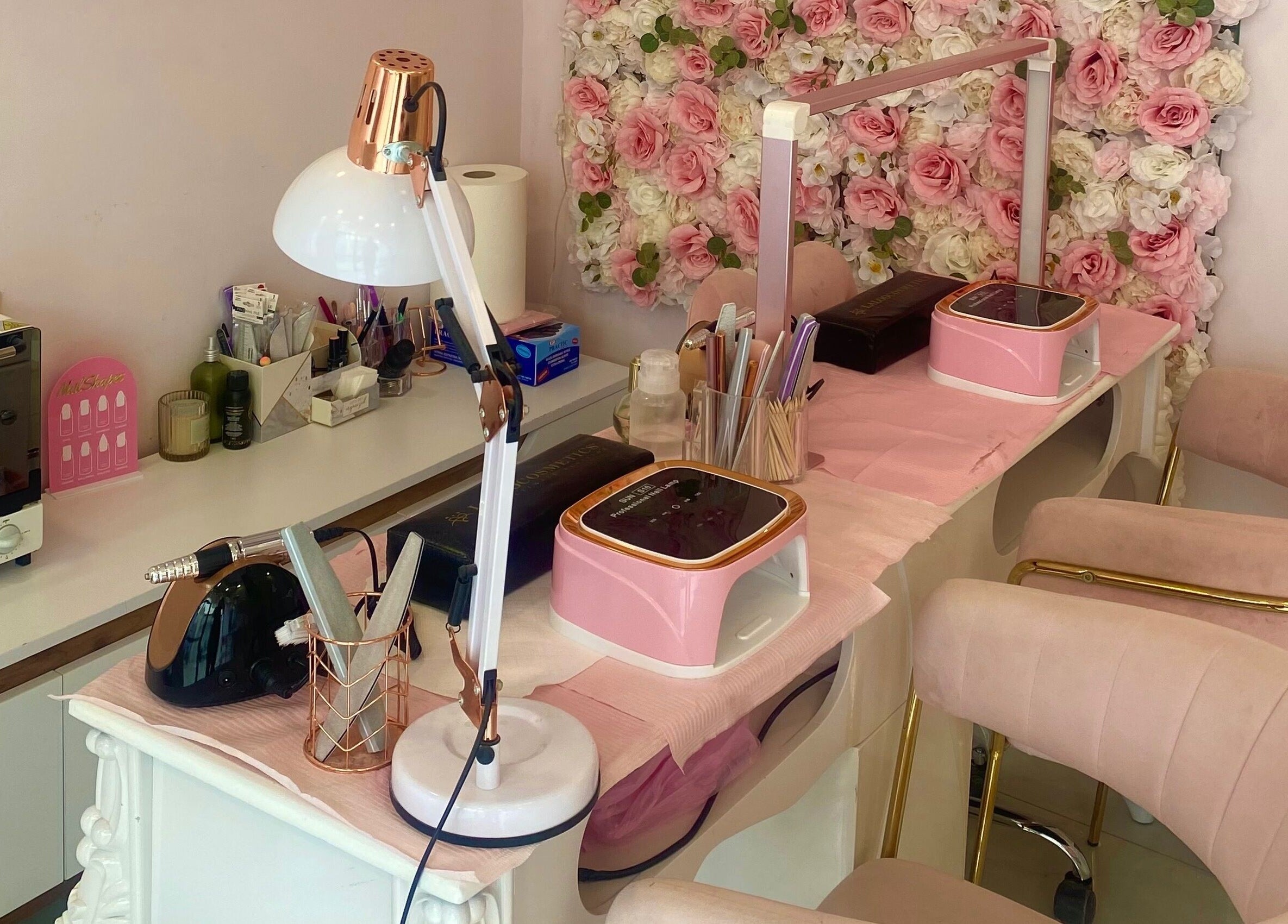 Stylish manicure station at Glow it, Limenas Chersonisou, GR with pink decor and floral backdrop.
