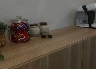 Beverage station at Salon 17, Tamworth, England, GB with snacks and coffee machine on wooden counter.