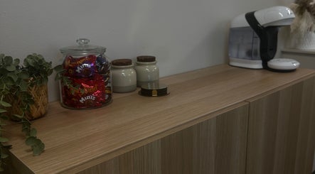 Beverage station at Salon 17, Tamworth, England, GB with snacks and coffee machine on wooden counter.