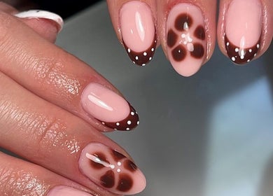 Elegant floral nail art at Salon 17, Tamworth, England, GB: brown petals and polka dots on nude pink base.