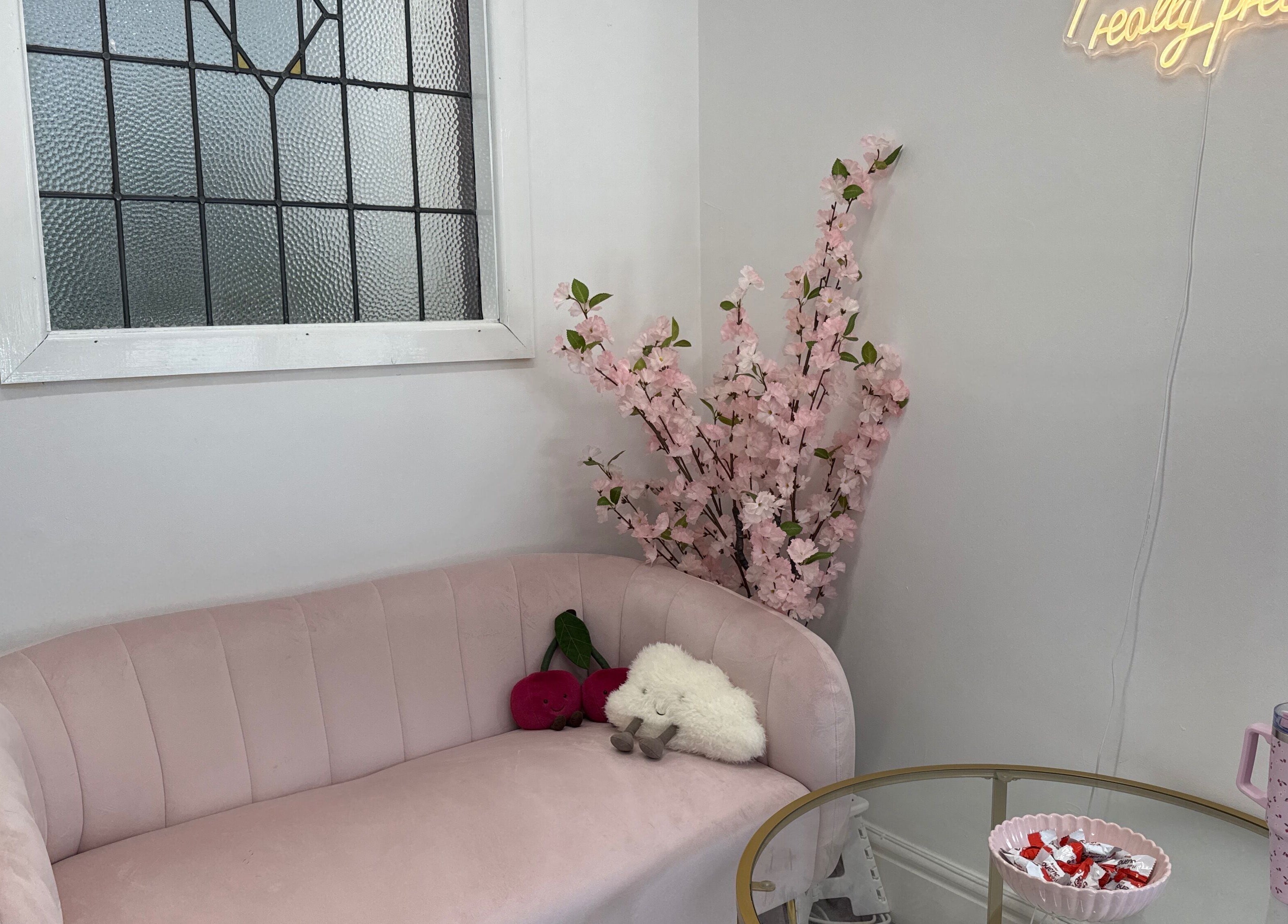 Inviting lounge at Mon Cheri by Megan Dermody, Ystalyfera, Wales, GB with pink sofa and floral decor.