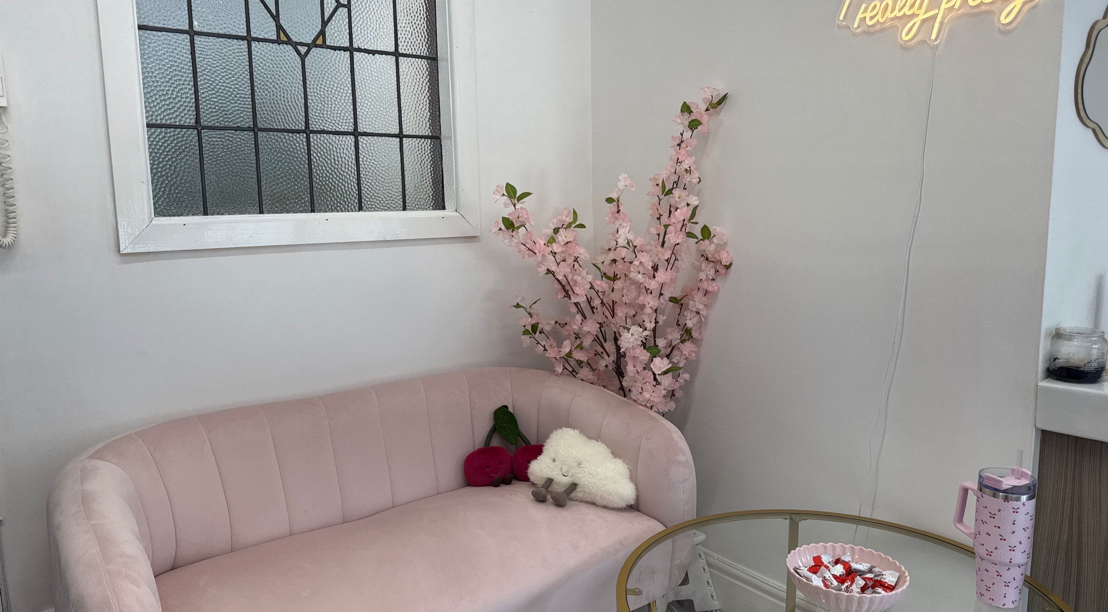Inviting lounge at Mon Cheri by Megan Dermody, Ystalyfera, Wales, GB with pink sofa and floral decor.