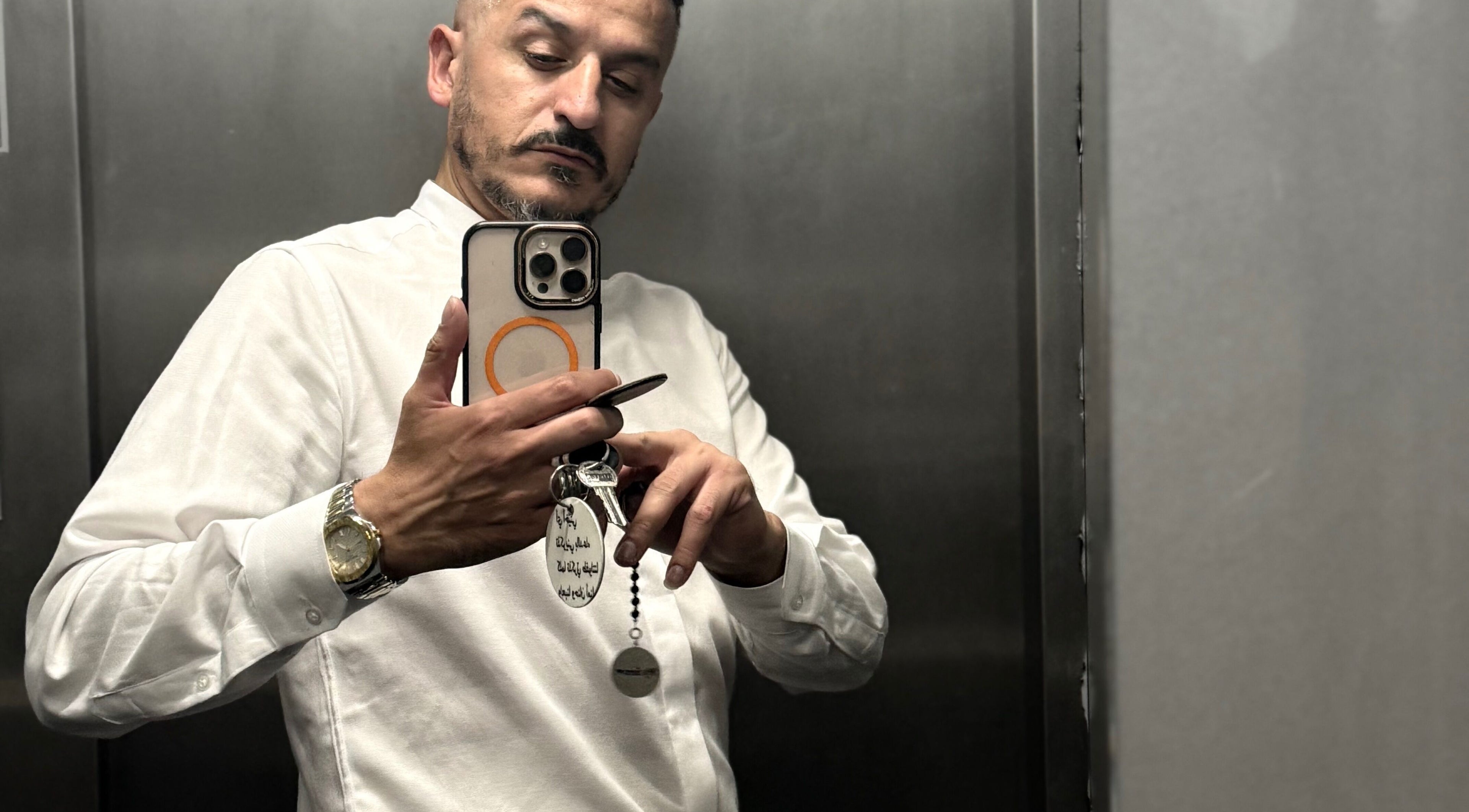 رجل يحمل هاتفًا في مصعد، يرتدي قميصًا أبيض في شعر و ذقن Hair and Beard שער ו זקן, ירושלים, ירושלים, IL.