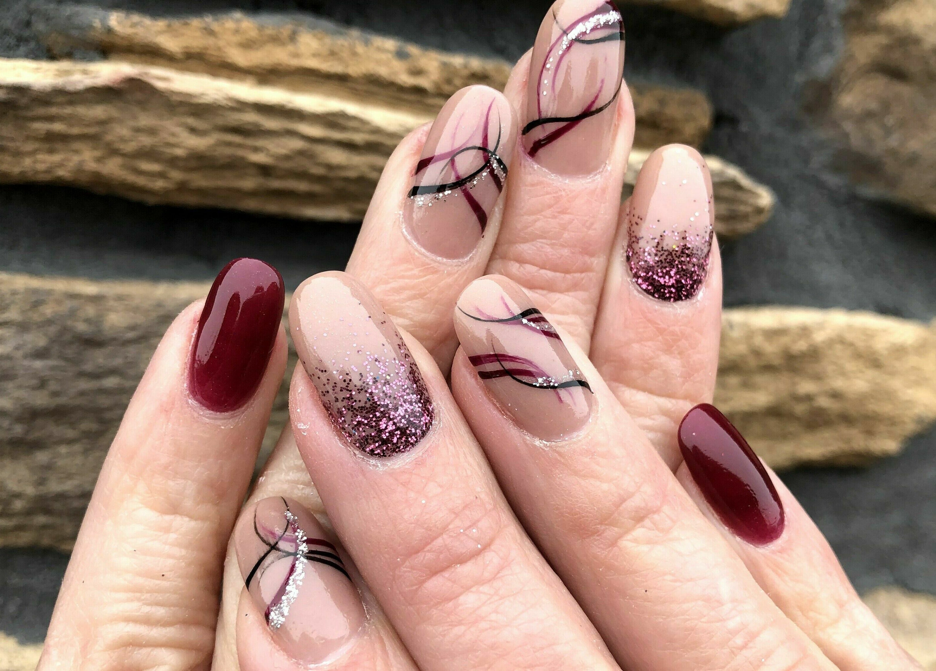 Stylish nail art featuring glitter and swirls at Natural Nail Bar, Appleton, Wisconsin, US.