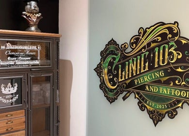 Ornate Clinic 103 sign in Harpenden, England, GB next to vintage display cabinet.