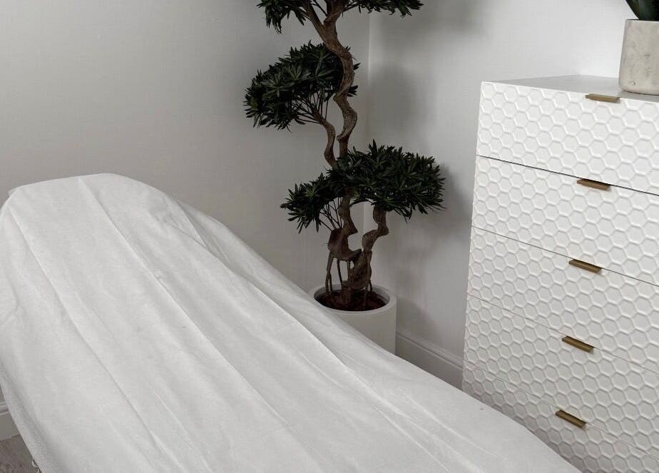 Treatment room at Clinic 103 in Harpenden, England. Features a white chair and decorative plant for a calming atmosphere.