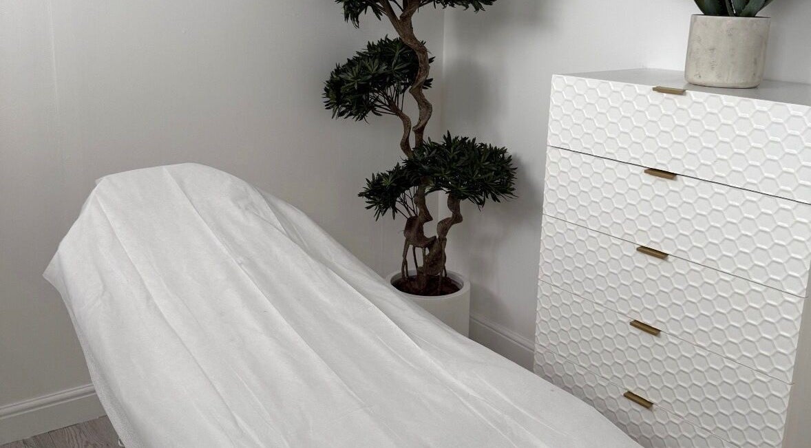 Treatment room at Clinic 103 in Harpenden, England. Features a white chair and decorative plant for a calming atmosphere.