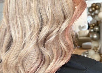 Elegant blonde waves styled at IsabelleRose.Hair in Ipswich, England, GB, with chic balloon decor in background.